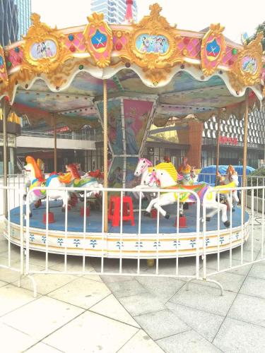 a carousel with horses on it in a city at Hampton By Hilton Foshan Sanshui in Foshan