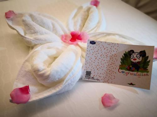 a white towel with a flower on it next to a box at Hampton By Hilton Foshan Sanshui in Foshan