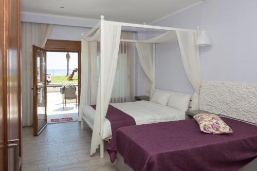 a bedroom with a canopy bed and a balcony at Sea to See in N&eacute;a P&eacute;ramos