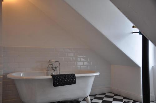 una vasca bianca in un bagno sotto una scala di Kames Hotel a Tighnabruaich