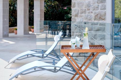 a table and chairs in front of a glass building at Luxury Villa Hvar Enigma with Pool in Vrboska