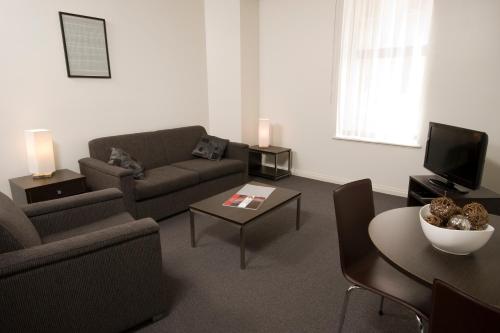 a living room with a couch and a table at Franklin Apartments in Adelaide