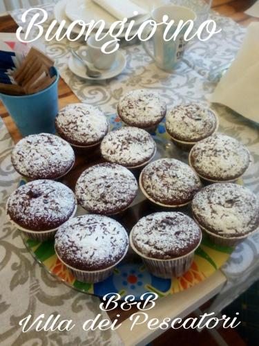 a plate of cupcakes sitting on a table at Villa dei Pescatori in LʼAquila