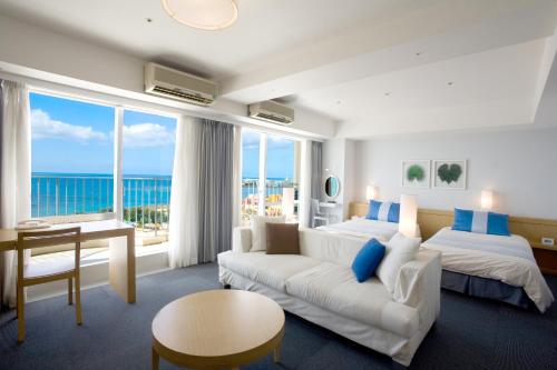 ein Wohnzimmer mit einem weißen Sofa und einem großen Fenster in der Unterkunft The Beach Tower Okinawa in Chatan