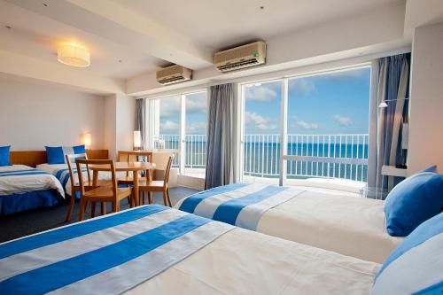 a hotel room with two beds and a view of the ocean at The Beach Tower Okinawa in Chatan