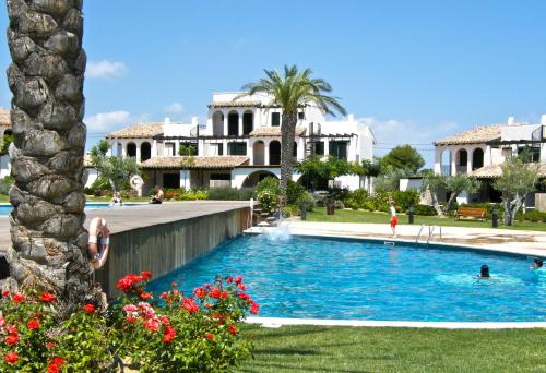 a swimming pool in front of a house at Lirio in L'Ampolla