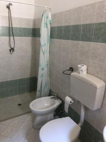 a bathroom with a toilet and a shower curtain at Hotel Villa San Giovanni in Erice