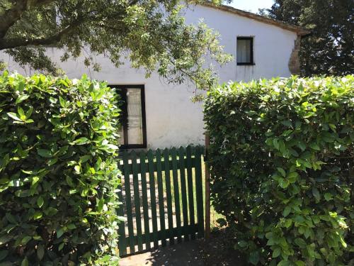 a fence in front of a white house with bushes at Agriturismo San Ottaviano in Monterotondo