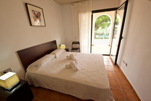 1 dormitorio con 1 cama con 2 toallas en Hibiscus, en L'Ampolla
