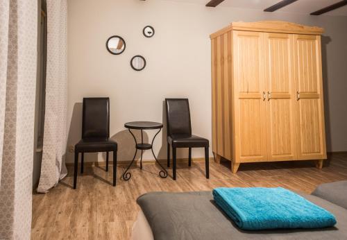 a bedroom with two chairs and a table and a cabinet at Leśna Oaza in Borek