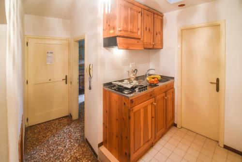 a kitchen with wooden cabinets and a counter top at Palazzetto San Lio, Rialto in Venice