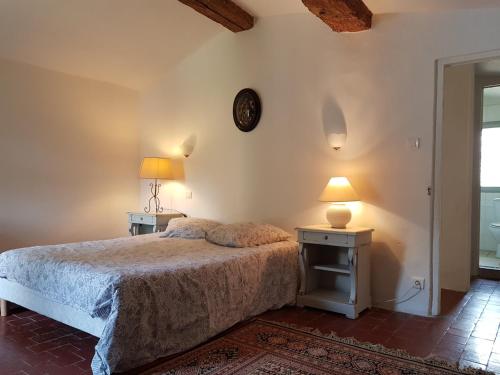 a bedroom with a bed and a clock on the wall at Les Gites de Catherine in Gargas