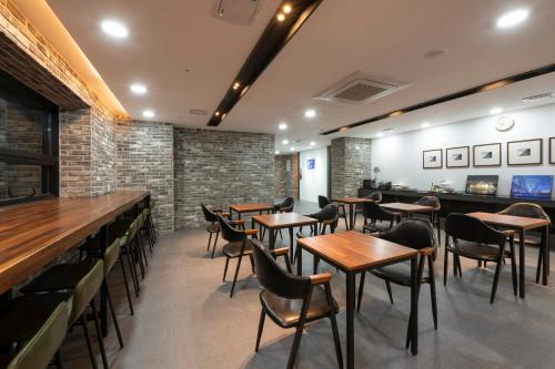 a restaurant with wooden tables and chairs and brick walls at Seomyeon Brown-dot hotel Gold in Busan