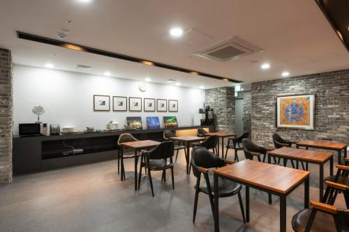 a restaurant with tables and chairs in a room at Seomyeon Brown-dot hotel Gold in Busan
