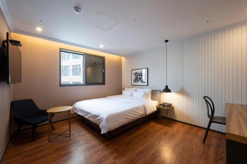 a hotel room with a bed and a window at Seomyeon Brown-dot hotel Gold in Busan