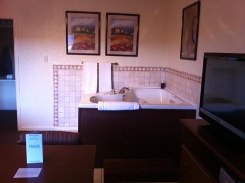 TV y baño con bañera. en Econo Lodge Inn & Suites en Abilene