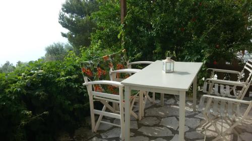 a white table and chairs on a patio at anerada / sun nature holidays in Athanion