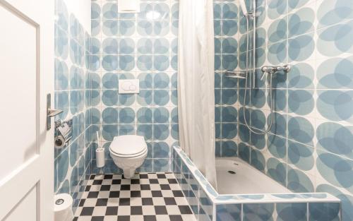 a bathroom with a blue and white tiled wall at Hotel Montana by Mountain Hotels in Davos