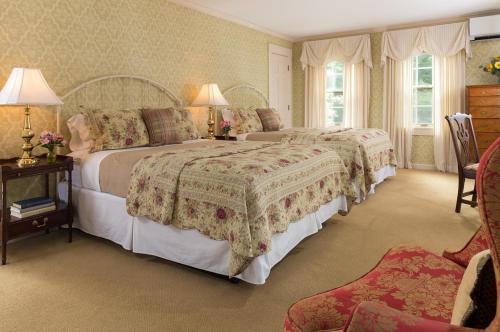 a bedroom with two beds and a table with two lamps at Deerfield Inn in Deerfield