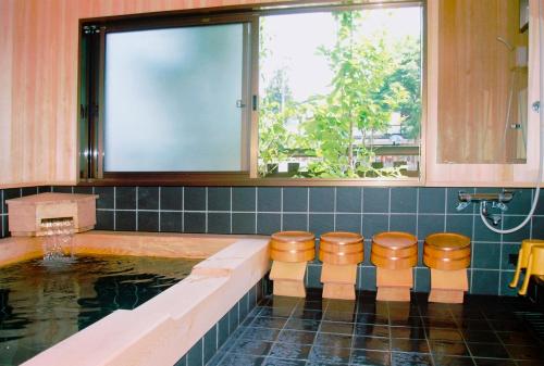 a bathroom with a pool of water with stools at Sumiyoshi Ryokan in Takayama