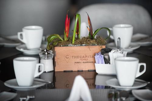 a table with white cups and a box with plants at The Capital Pearls Hotel in Durban