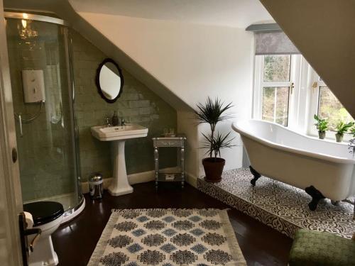 Rosebank House Bed & Breakfast في ستراثير: حمام مع حوض استحمام ومغسلة