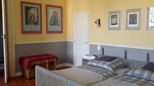 Sallèles-dʼAudeにあるLa Maison du Docteurのベッドルーム1室(ベッド2台、赤いスツール付)