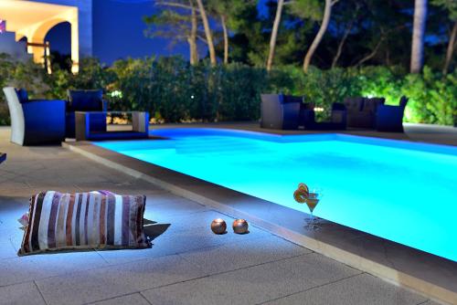 a swimming pool at night with a glass of wine at Mam in Vir