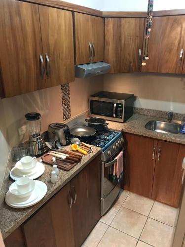 a kitchen with a stove and a microwave at Casa Balam in Rincon de Guayabitos