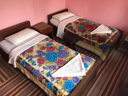 two beds in a small room with at Kathmandu Madhuban Guest House in Kathmandu
