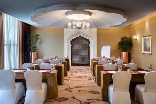 a conference room with tables and chairs and a chandelier at Bab Al Qasr Hotel in Abu Dhabi