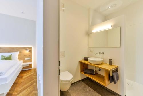 a white bathroom with a sink and a toilet at Bett´n Glück - Übernachtung & Frühstück in Zusmarshausen