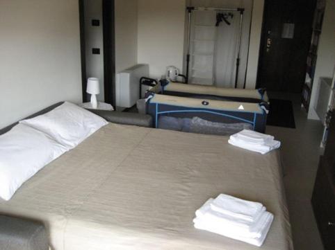 a room with a bed with two towels on it at Suite Carpiano in Melegnano