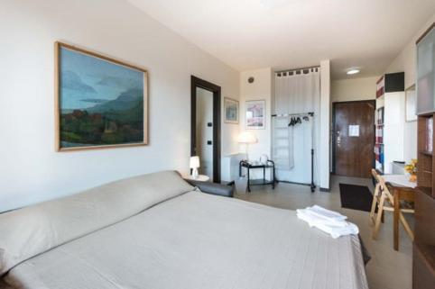 a bedroom with a white bed and a desk at Suite Carpiano in Melegnano
