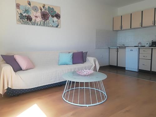 ein Wohnzimmer mit einem Sofa und einem Tisch in der Unterkunft Apartman Franc in Zadar