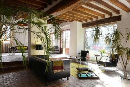 a living room with a couch and plants in it at Domaine de l'Ocrerie in Pourrain