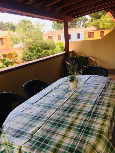 einen Tisch mit einem karierten Tischtuch auf dem Balkon in der Unterkunft Green House in Porto Pino