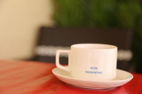 a coffee cup sitting on a plate on a table at HOTEL MADNI ROYALE (50 Mtrs from Dargaah), Ajmer in Ajmer
