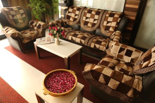 a living room with couches and a table with flowers at HOTEL MADNI ROYALE (50 Mtrs from Dargaah), Ajmer in Ajmer