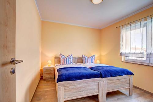 ツィノヴィッツにあるHaus Werder Wohnung 4 _ mit Gaskamのベッドルーム1室(青いシーツと窓付)