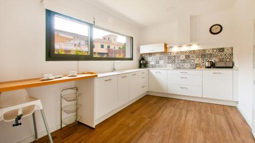 een keuken met witte kasten en een raam bij Villa Jade I in Can Picafort
