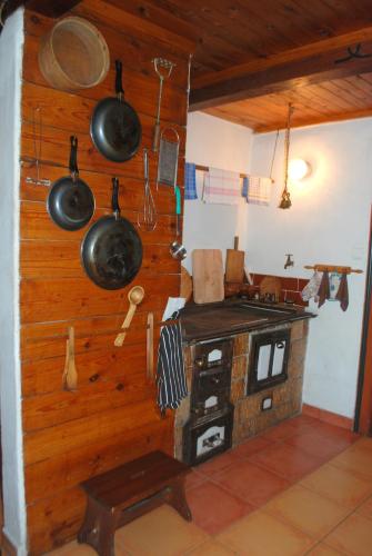 a kitchen with a stove and pots and pans at Chalupa Bumbálka in Mníšek