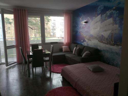 a living room with a couch and a table at Apartament Slavia Rosa in Międzyzdroje
