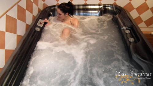 a woman is sitting in a jacuzzi tub at Las Encarnas in Braojos de la Sierra