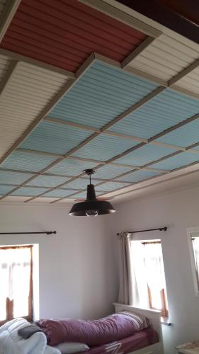 a room with a ceiling with a ceiling fan and two windows at Vernon Villa Stone 1887 in Kastoria