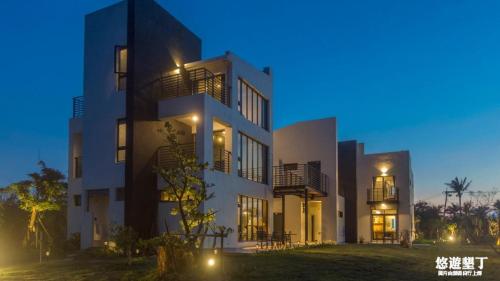 a large white building at night with lights at Lin's Forest in Hengchun