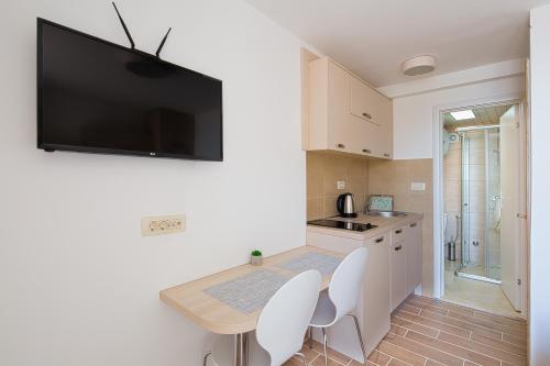 a kitchen with a flat screen tv on the wall at Apartments Djuro Rafailovic in Budva