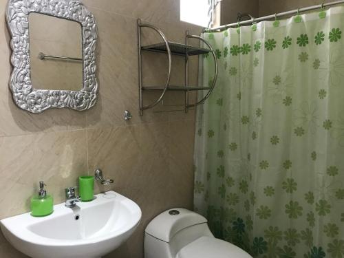 a bathroom with a sink and a toilet and a mirror at Cusco Cozy Apartment in Cusco