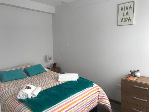 a bedroom with a bed with towels on it at Cusco Cozy Apartment in Cusco