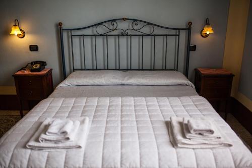 a bed with white sheets and towels on it at Villa Moorings in Barga